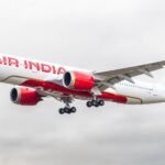 Air India Airbus A350 landing at an airport in England against a cloudy sky.