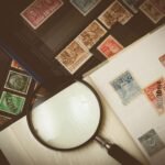 Explore a detailed view of vintage postage stamps through a magnifying glass, highlighting intricate designs.