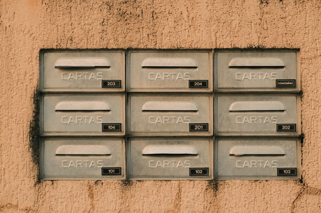 Rustic metal mailboxes labeled 'CARTAS' on a textured wall, Natal, Brazil.