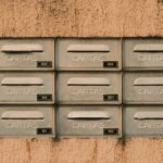 Rustic metal mailboxes labeled 'CARTAS' on a textured wall, Natal, Brazil.