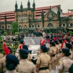 Vibrant parade with police officers celebrating Independence Day in Mumbai, India, near Chhatrapati Shivaji Terminus.