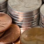Detailed image of stacked American coins including pennies and nickels, representing savings and finance.
