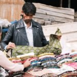 People browsing colorful fabrics at a Bengaluru street market.