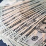 Close-up shot of multiple US twenty dollar bills spread out, symbolizing wealth and finance.