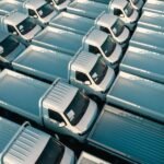 Aerial view of white pickup trucks parked in rows, emphasizing symmetry and industrial style.