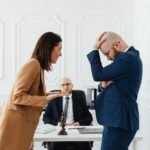A couple having a heated argument in a law office with their attorney observing.