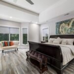 Sophisticated modern bedroom featuring luxurious furniture, large windows, and stylish decor with ample natural light.