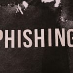 Abstract representation of phishing with the text on a textured dark surface.