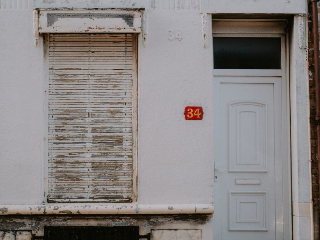 Classic white house exterior with a closed shutter and number 34.