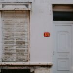Classic white house exterior with a closed shutter and number 34.