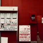 City environment with notices and fire hose on a vibrant red wall.