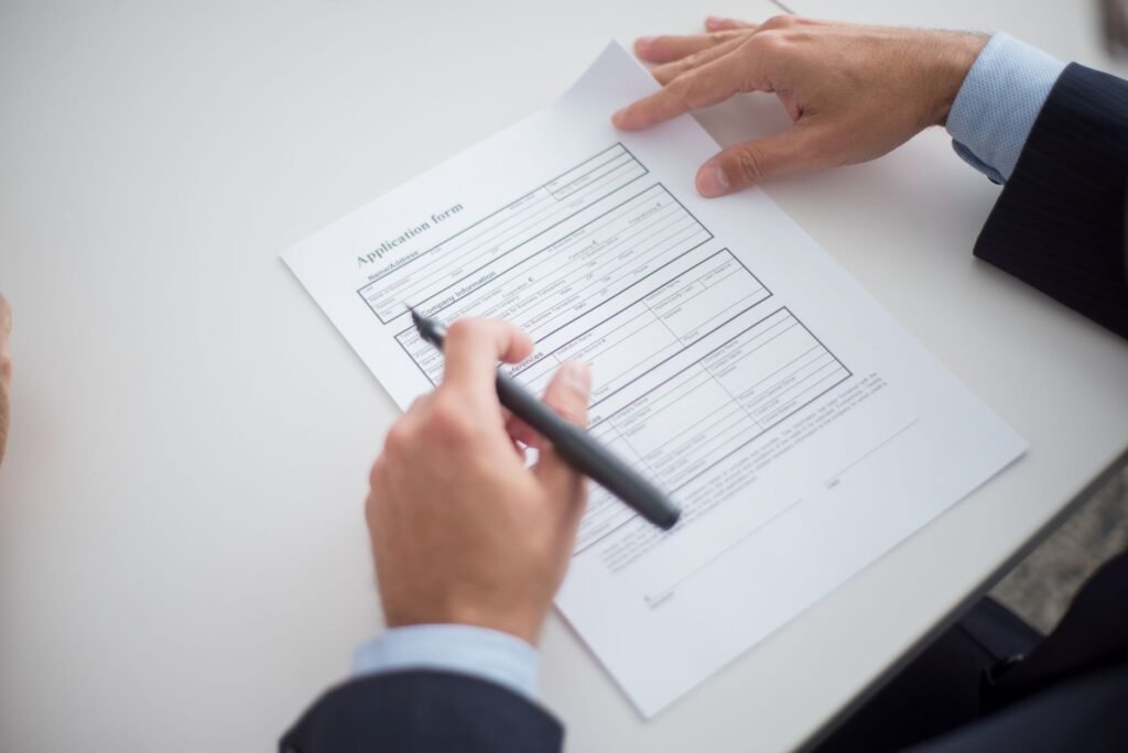 Close-up of a business professional reviewing an application form at a desk.
