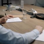 Professional setting of a business meeting with individuals signing documents on a conference table.