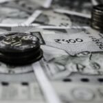 A detailed close-up of Indian currency notes and coins, highlighting financial themes.
