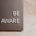 Be Aware wording on brown textured perforated surface, offering copyspace.