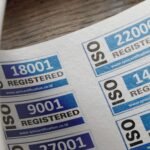 ISO certification stickers with registration numbers on paper.