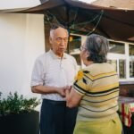 Senior Asian couple holding hands and expressing love and affection in a sunny outdoor setting.