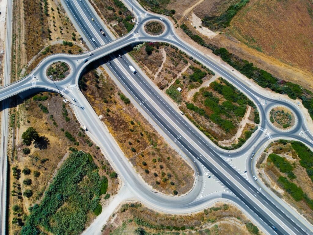 Top-down aerial view showcasing highways and roundabouts intertwined with greenery.