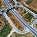 Top-down aerial view showcasing highways and roundabouts intertwined with greenery.