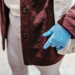 High angle of crop unrecognizable female client in latex gloves with zero waste shopping bag selecting food in grocery store