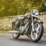 A vintage Royal Enfield motorcycle parked on a street in New Delhi, India, showcasing its classic design.