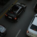 Aerial shot showing multiple cars driving on a city road during the evening, illustrating urban traffic.