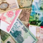 Colorful assortment of international paper currencies from various countries in a flat lay.